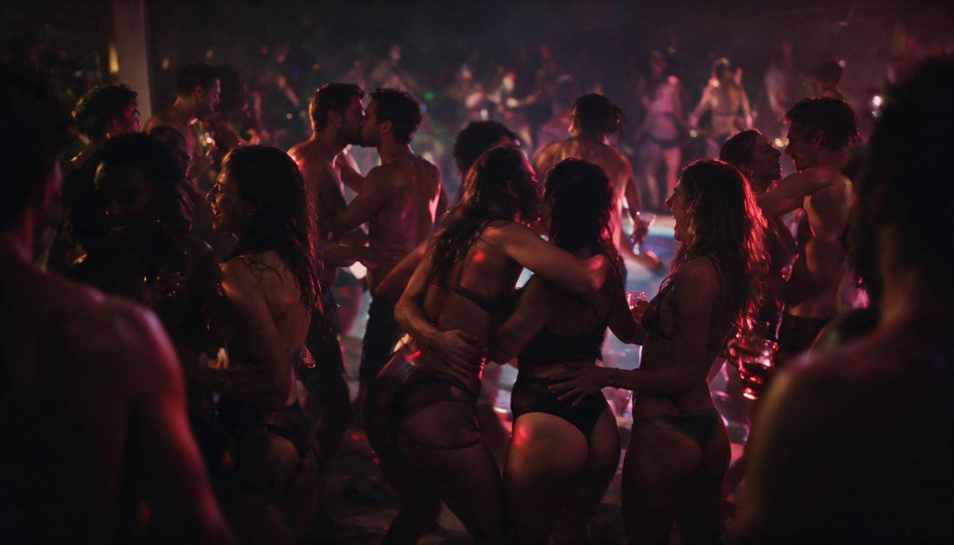 Packed HouseMatez dance floor beside the pool, guests dancing close together under red and violet light